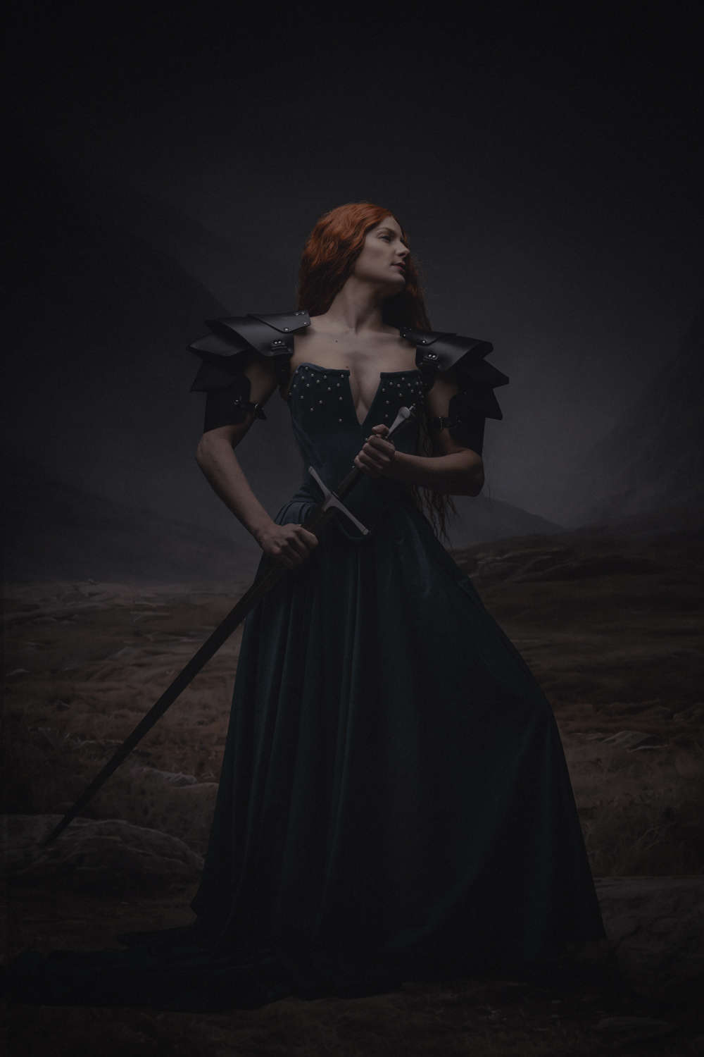 Fine art portret vrouw met rood haar, zwaard en halo knielend op bergklif — Meesterwerk Ace Photography Zaltbommel